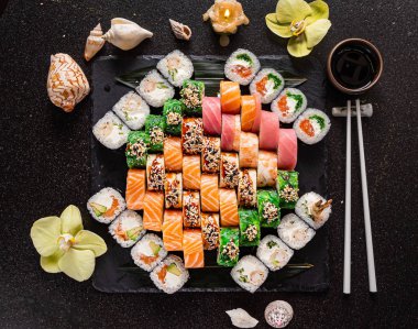 Siyah arkaplanda suşi var.