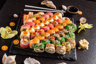 Siyah arkaplanda suşi var.