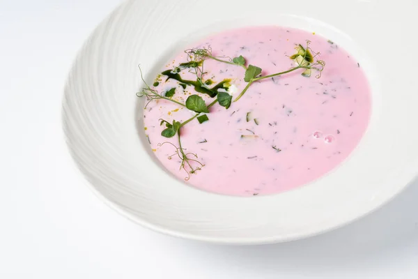 cold beetroot soup on the white background, close up