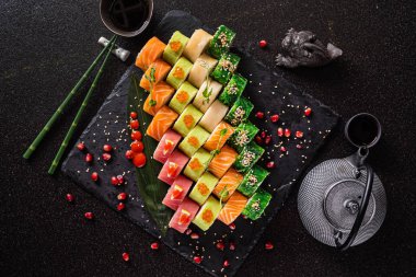 Siyah arkaplanda suşi var.