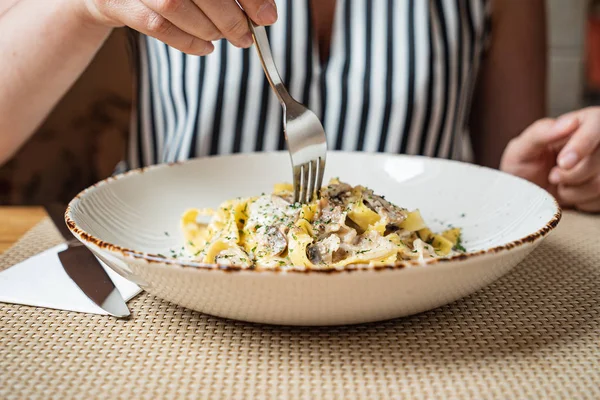 woman eating Spaghetti Carbonara with chicken and chees