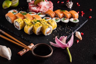 Siyah arkaplanda suşi var.