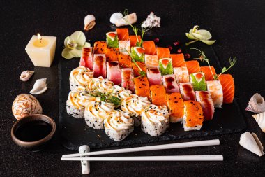 Siyah arkaplanda suşi var.