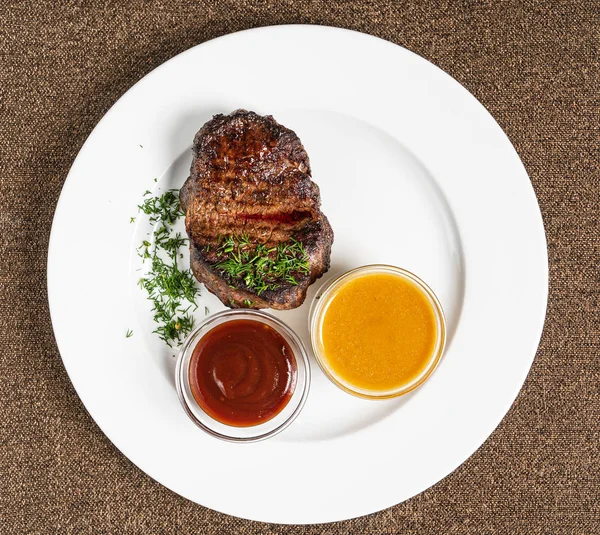 steak with sauces on white plate