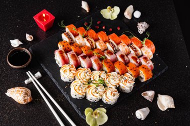 Siyah arkaplanda suşi var.