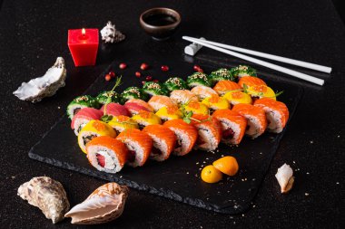 Siyah arkaplanda suşi var.