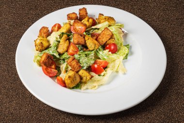 Sezar salatası beyaz plaka üzerinde