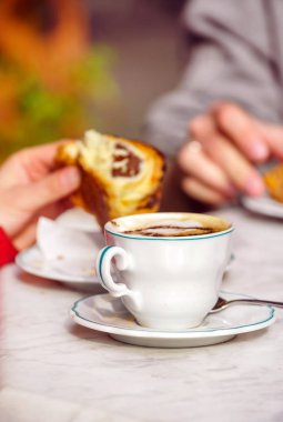 Kafede kruvasan ve kapuçino.