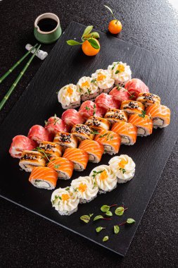 Siyah arkaplanda suşi var.