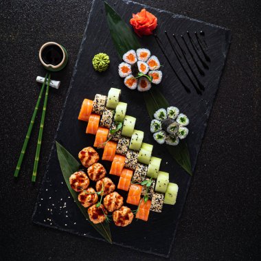 Siyah arkaplanda suşi var.