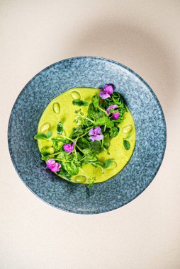 Yeşil bezelye kremalı çorba ve yenilebilir çiçekler.