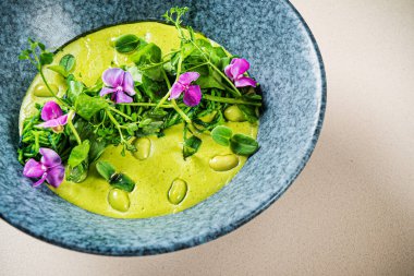 Yeşil bezelye kremalı çorba ve yenilebilir çiçekler.