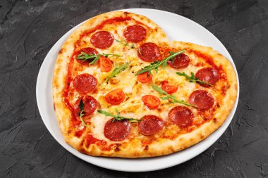 Kalp şeklinde et ve sebzeli pizza. Sevgililer Günü için romantik aşk konsepti. 