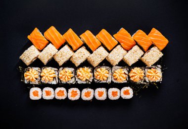 Siyah arkaplanda suşi var.