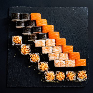 Siyah arkaplanda suşi var.