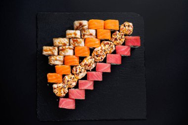 Siyah arkaplanda suşi var.