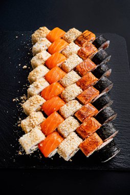 Siyah arkaplanda suşi var.