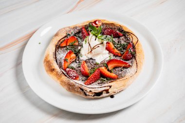 Çikolatalı ve dondurmalı çilekli pizza.