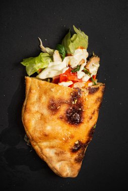 Siyah zemin üzerinde calzone pizza