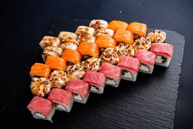 Siyah arkaplanda suşi var.