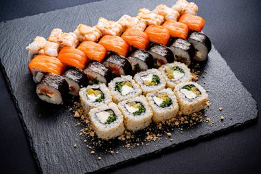 Siyah arkaplanda suşi var.