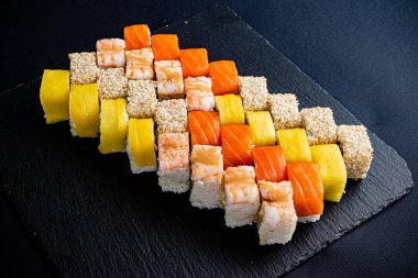 Siyah arkaplanda suşi var.