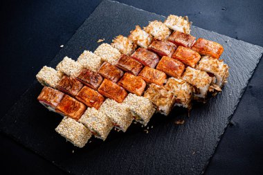 Siyah arkaplanda suşi var.