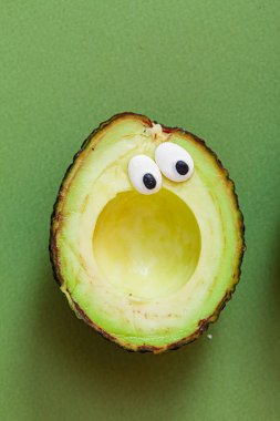 Yeşil arka planda komik bir avokado.