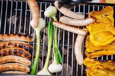 Şef sebzeli ızgara sosis yapıyor.