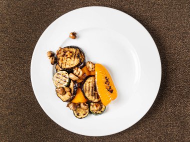 Beyaz tabakta ızgara sebze.