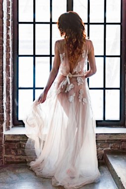 Gelinlikli genç gelin elinde buket tutuyor.