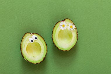 Yeşil arka planda komik bir avokado.