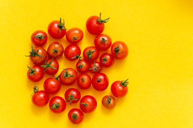 Sarı arka planda küçük vişne domatesleri