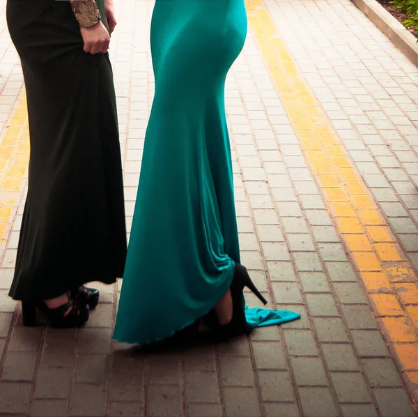 women dressed with long evening gowns