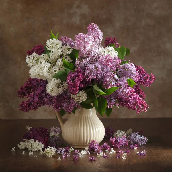 Natura morta fiori lilla in un vaso sul tavolo — Foto Stock