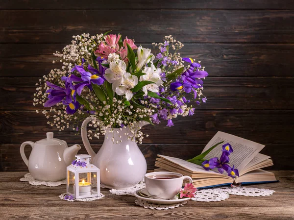 Hermosa naturaleza muerta con flores, una vela, un libro y una taza — Foto de Stock