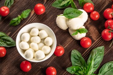 mozzarella peynirli kiraz domatesli ve fesleğenli ahşap tahtada..
