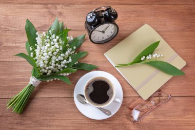 Vadi çiçekleri, kahve, kitap ve çalar saatle.