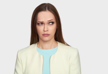 kadın bir kenara ciddi görme ile arıyorsunuz. Kız sorunlar hakkında düşünme. Gri arka plan üzerinde izole