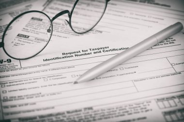 Federal Gelir Vergisi Kanunu W9 formu. Kalem ve gözlük.