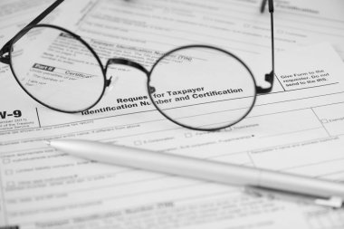 Federal Gelir Vergisi Kanunu W9 formu. Kalem ve gözlük.