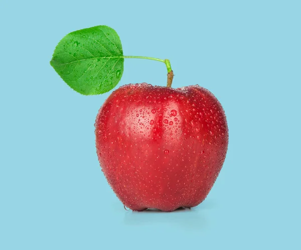 Ripe red apple with a leaf. Isolated on a blue background.
