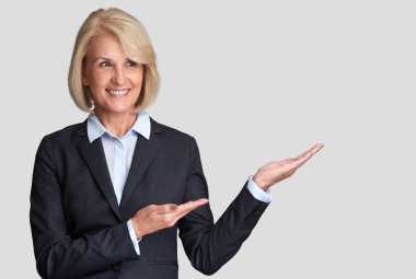 Yaşlı iş kadını bir boşaltmak sunulması. Gri arka plan üzerinde izole