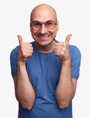 Başparmaklarını mutlu neşeli kel adam ortaya çıktı. Gözlük gülümseyen adam. Gri arka plan üzerinde izole