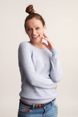 Dişlek gülümseyen neşeli kadın. Stüdyo gri duvar üzerinde izole