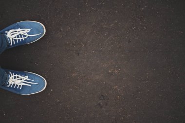 Asfalt kentsel grunge arka plan üzerinde spor ayakkabıları. Ayak şehir sokak üzerinde.