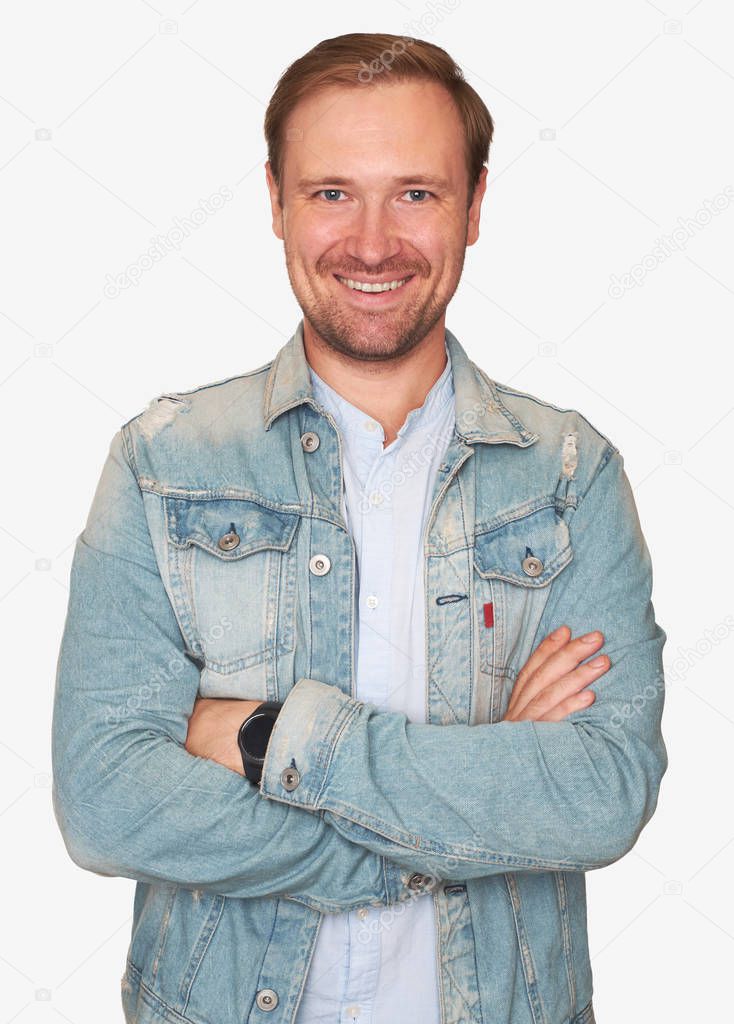 Handsome young man looking at camera isolated on grey studio background. Portrait of happy guy smiling with hands folded