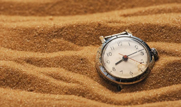 old retro watch on a sand with copy space