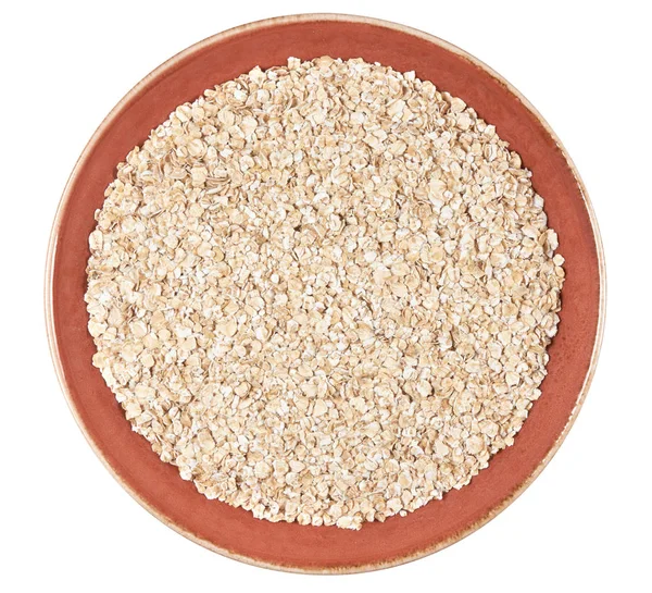 Yulaf gevreği beyaz kırpma yoluyla izole. bir plaka üzerinde çiğ yulaf ezmesi