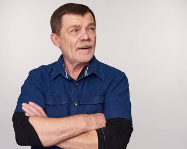 Yaşlı adam uzak rahat gömlek arıyor. Gri arka plan üzerinde izole